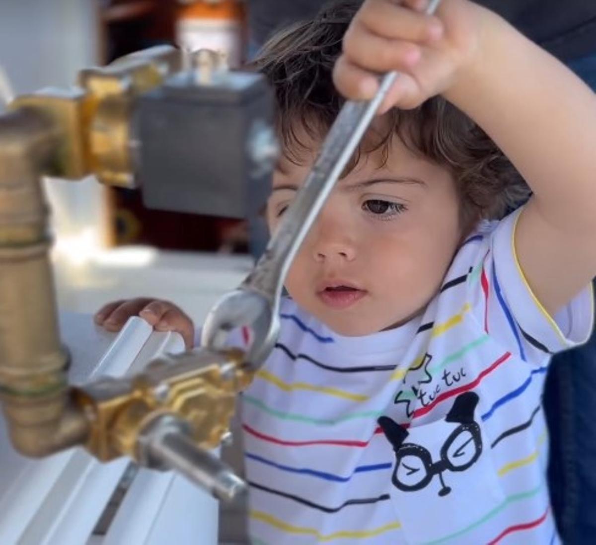 El pequeño Leo, atornillando alguna pieza en el velero Forquilla.