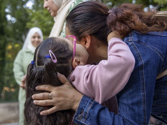 Foto: Una niña abraza a su madre a las puertas de un colegio (EFE/Raquel Manzanares)