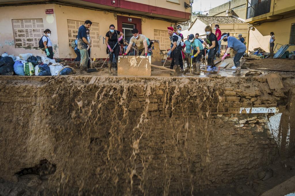 Vecinos retiran lodo acumulado en una calle de Paiporta.