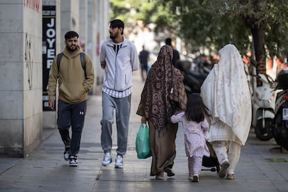 Varias personas pasean este domingo por Barcelona.