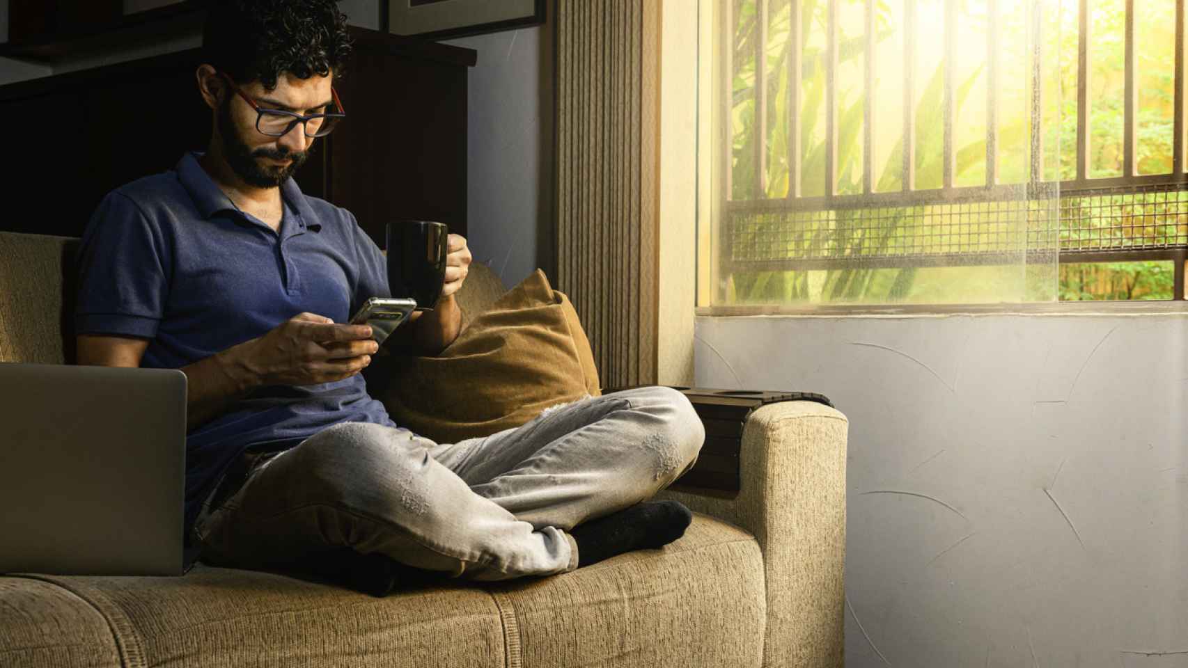 Un hombre consulta un mensaje en su teléfono móvil.