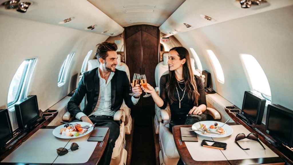 Pareja haciendo un brindis en un avión.