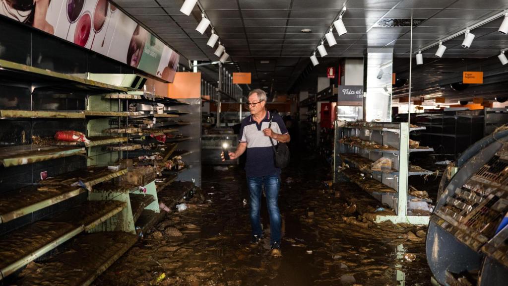 Un hombre busca alimentos en uno de los supermercados de la ciudad, totalmente saqueado y a oscuras. Fotografía realizada con Leica SL3.