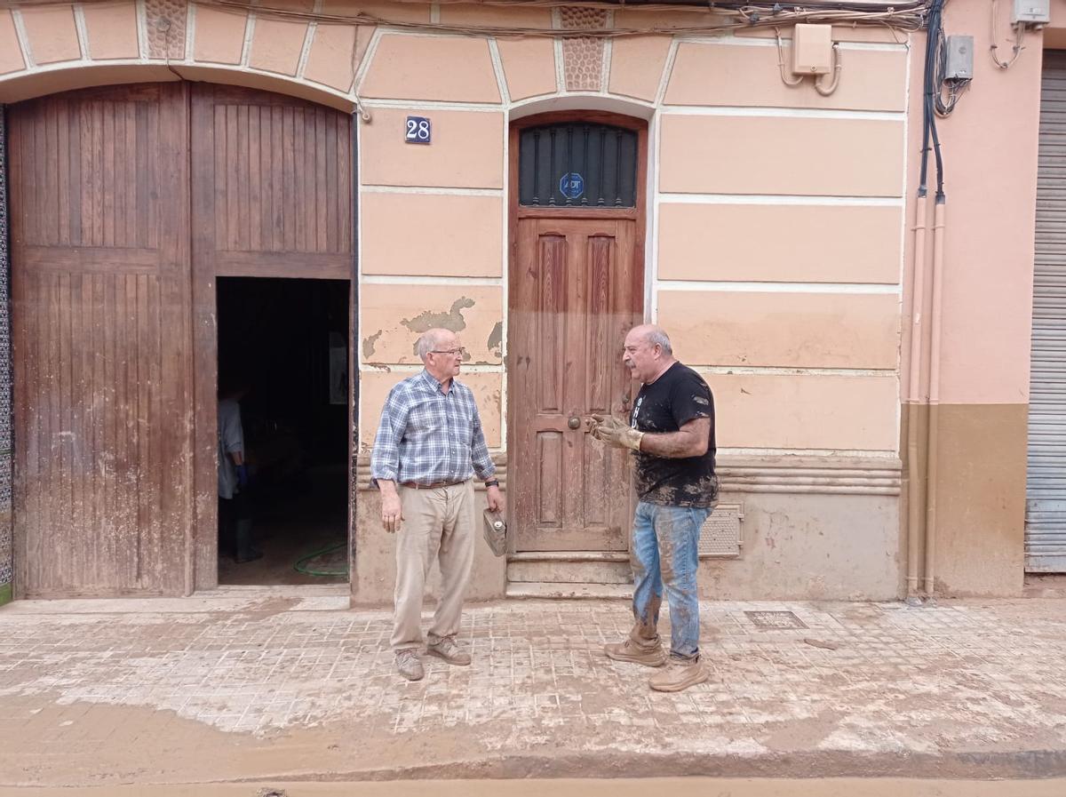 Conversación entre Pepe y Jesús. En la pared se aprecia la marca de la riada