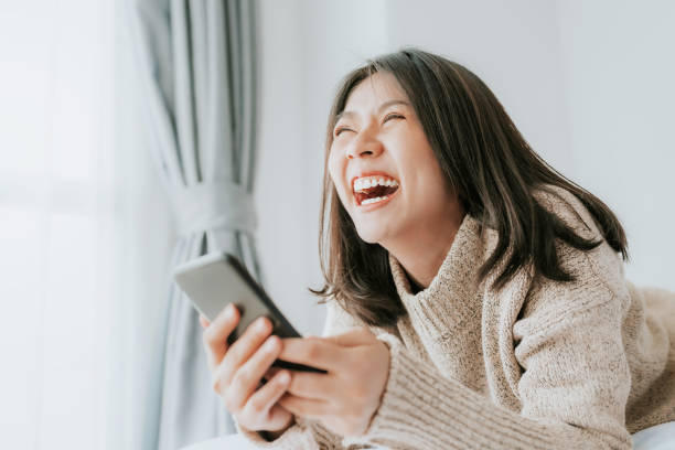 an-laughing-while-lying-on-the-bed-with-smartphone.jpg