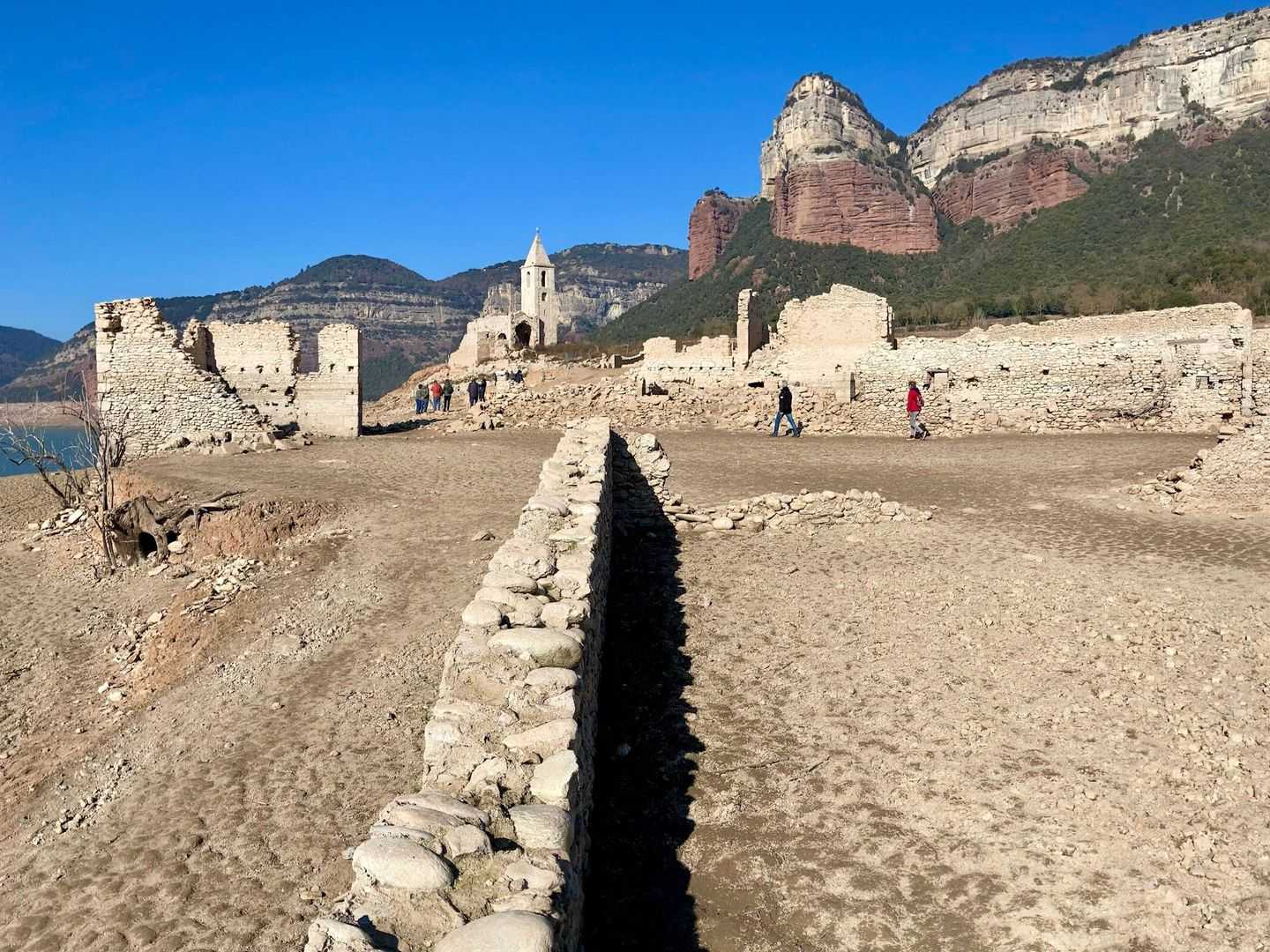 Turistas recorriendo estos días el pueblo de Sant Romà de Sau. (Jose Luis Gallego)