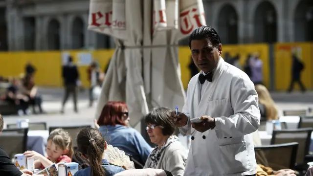 Un camarero de origen extranjero trabajando en un bar.