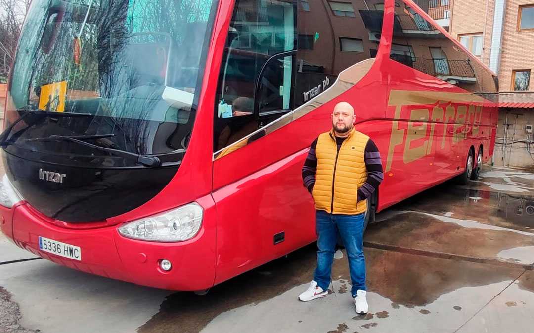 Claudio junto a uno de los autobuses con los que trabaja habitualmente./ L.C.