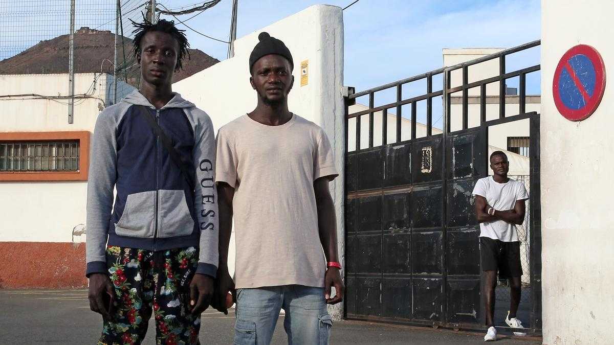 Saikou y Alhayie, de Gambia, en la puerta que da acceso al centro para migrantes 'Canarias 50', en Las Palmas de Gran Canaria