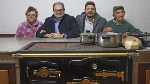 Fernando Núñez, en la cocina de la casa de su prima Angelitiña (a la izquierda) en Riobó, junto a su hijo y Manolo, otro familiar. 