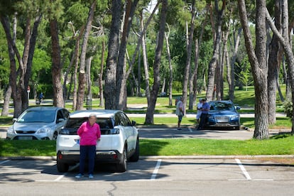 Hombres mayores que practican 'cruising' esperan en un estacionamiento de la Casa de Campo de Madrid.